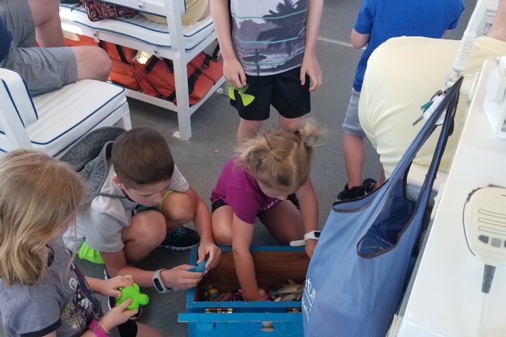 Kids digging thru a toy Treasure Chest on a HHI boat tour